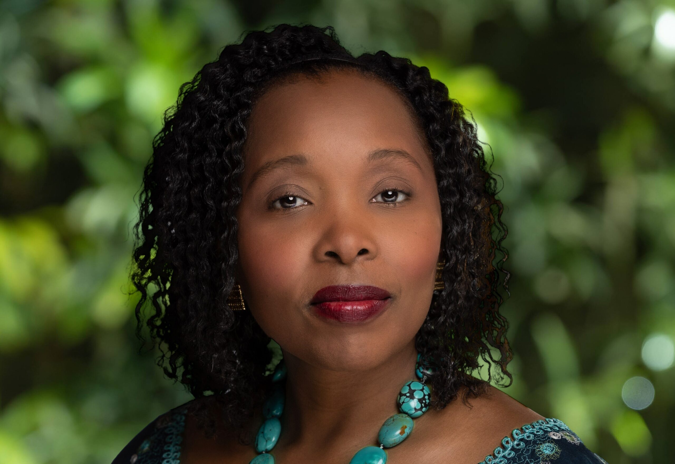 Profile shot of a woman in front of a blurred green background