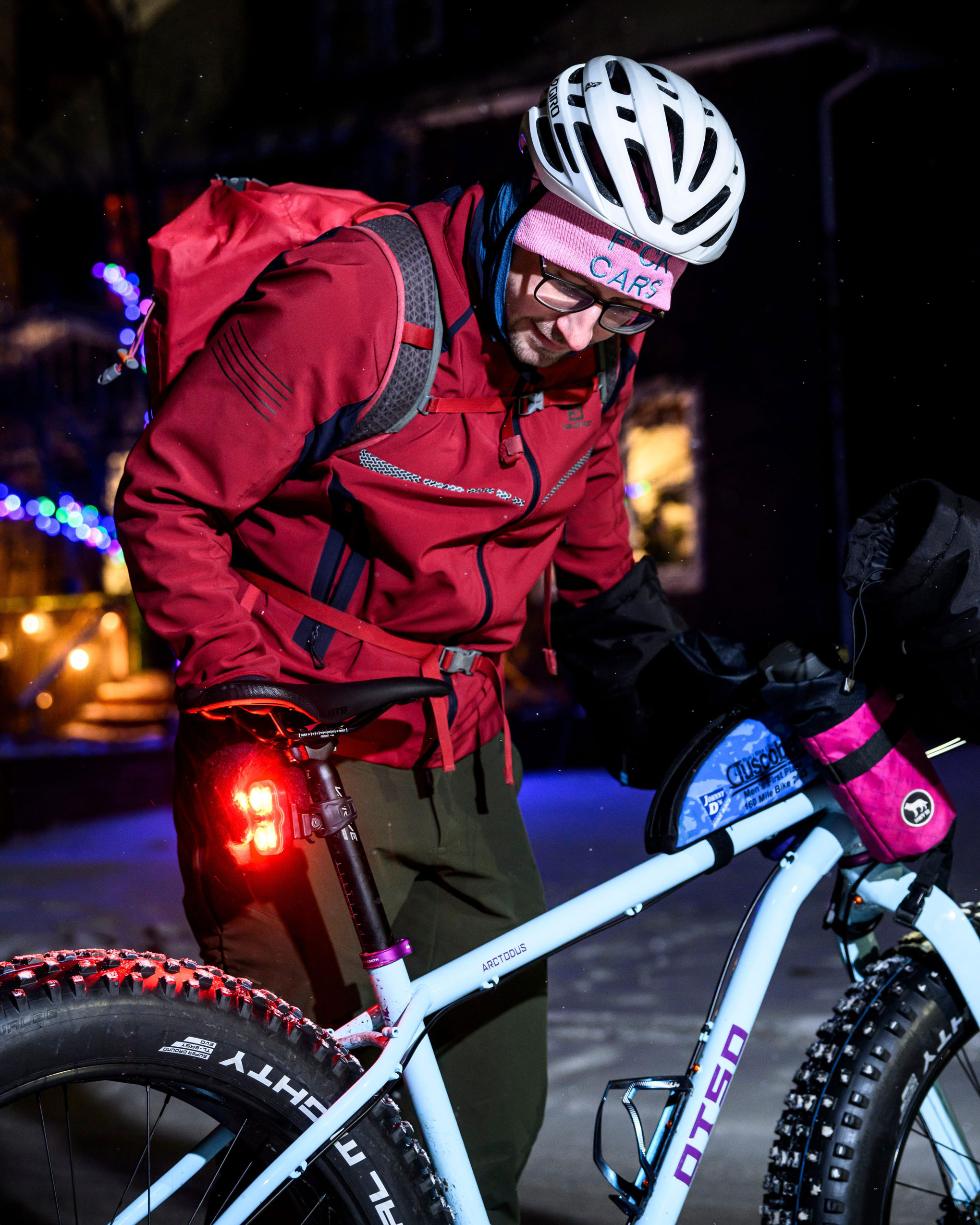 Winnipeg symphony orchestra bassist Daniel Perry in cycling attire looks at a bike on a snowy street