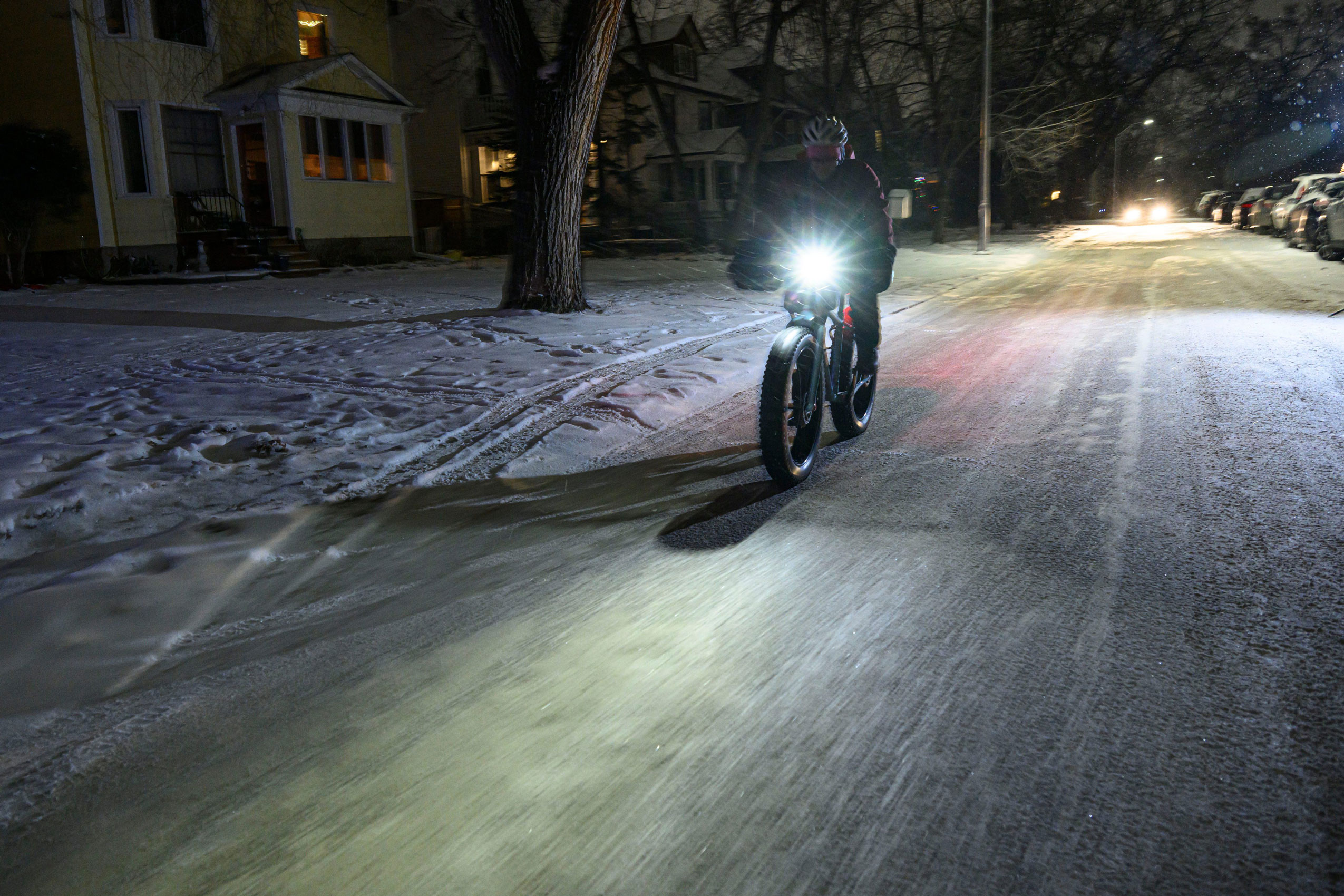 Winnipeg symphony orchestra bassist Daniel Perry rides a bike on a dark snowy street