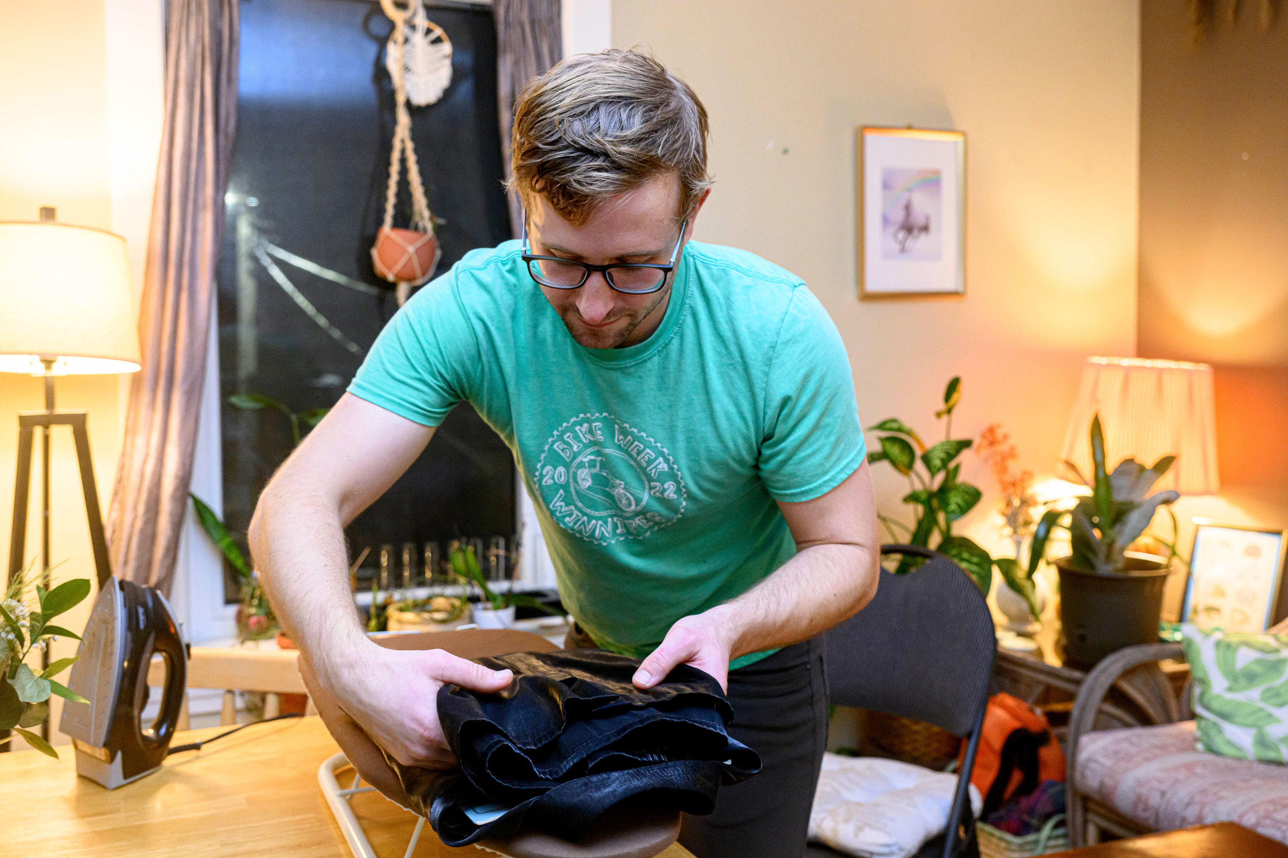 Winnipeg symphony orchestra bassist Daniel Perry in a t-shirt packs a small bag at home
