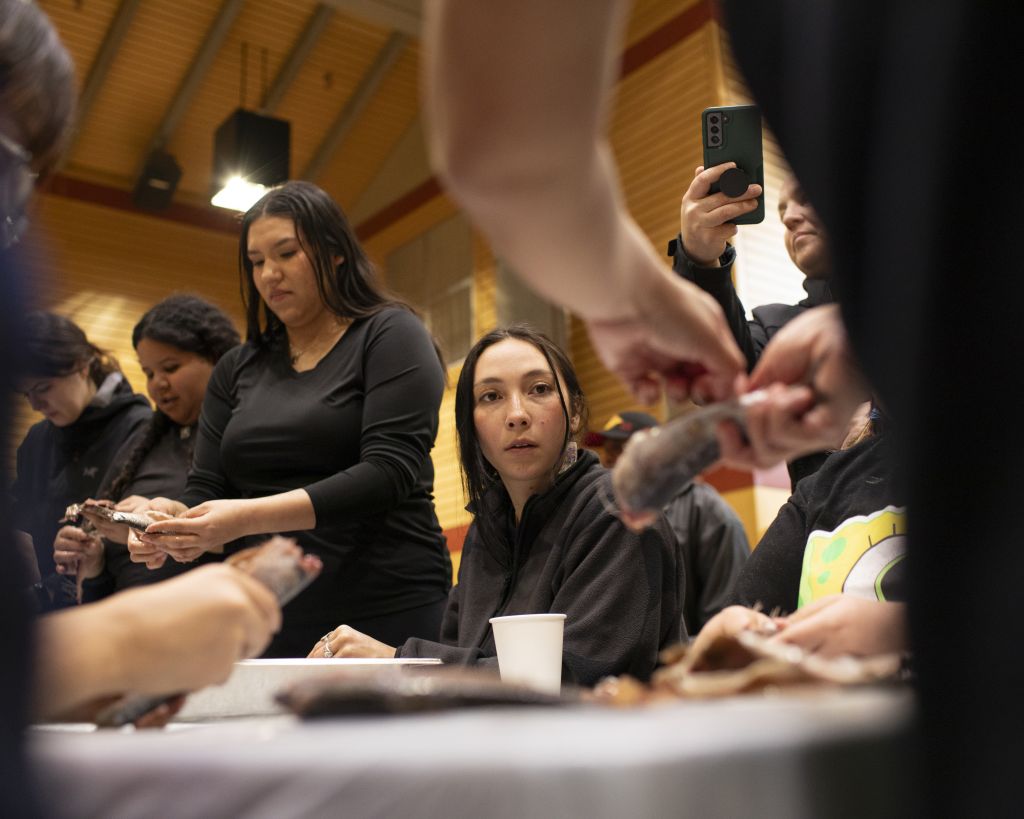 A youth watches Stee’pulwutt (Shirley Louie) from Stz’uminus First Nation eagerly as she demonstrates how to process slhawt’.